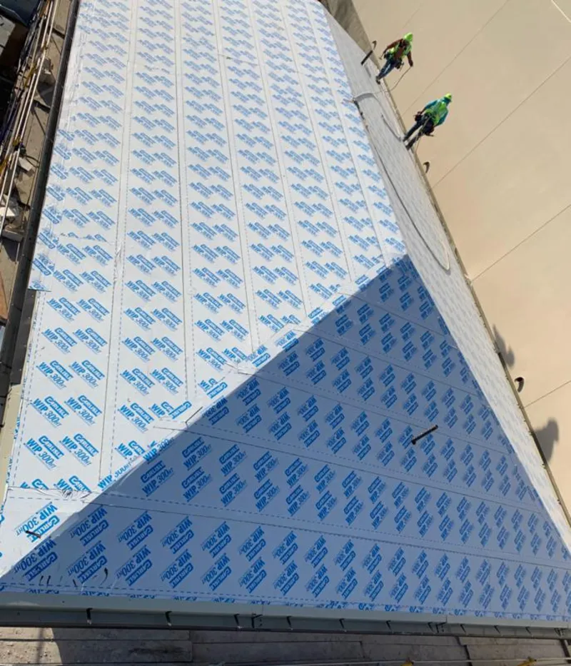 Professional roofers installing underlayment on a metal roof in Lower Oxford